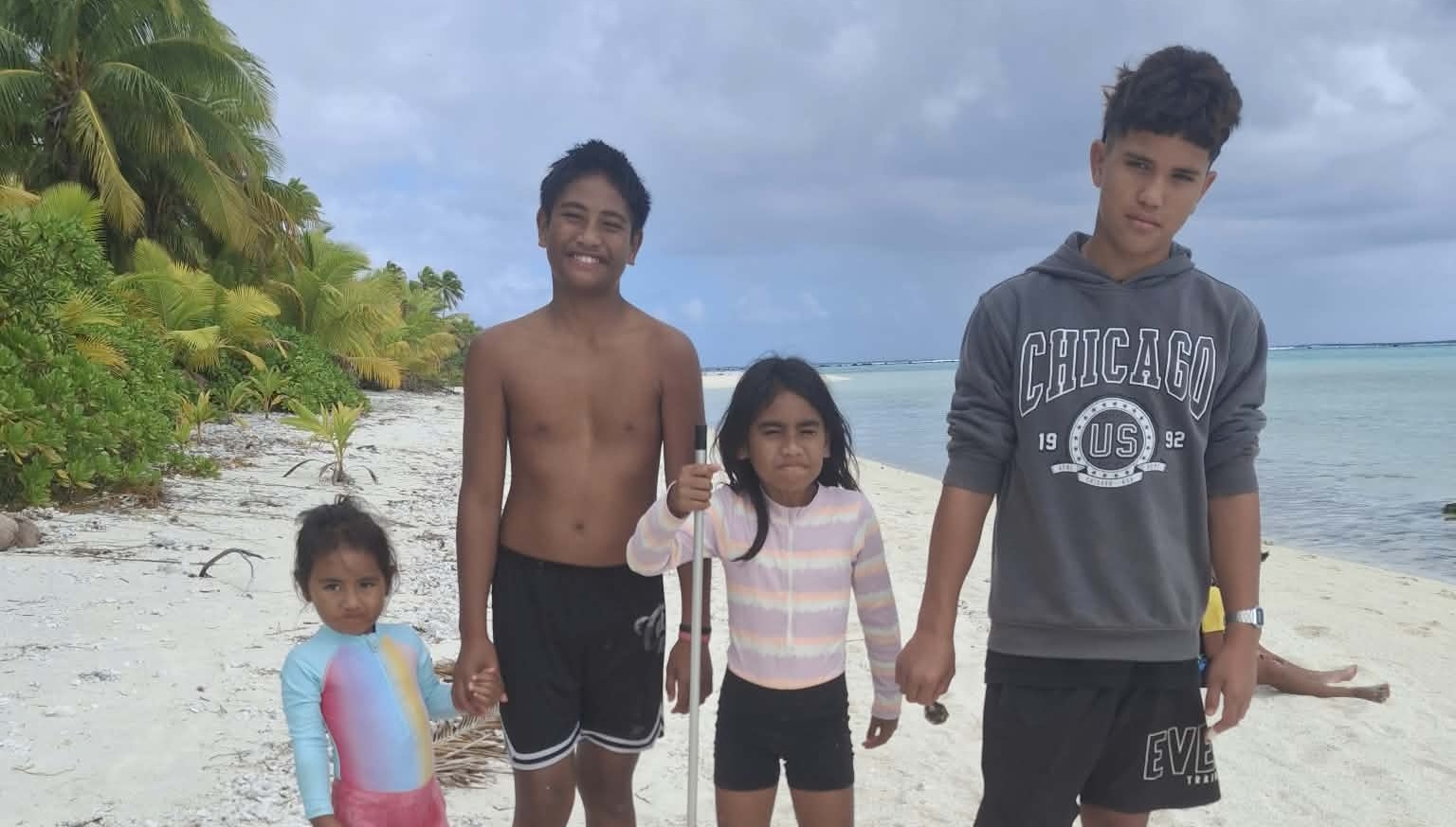 Four children exploring a palm-fringed island in Aitutaki